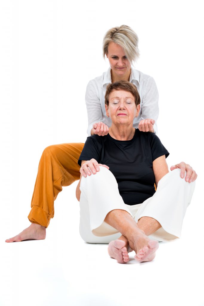 senior woman receiving thai massage from female thaimassager